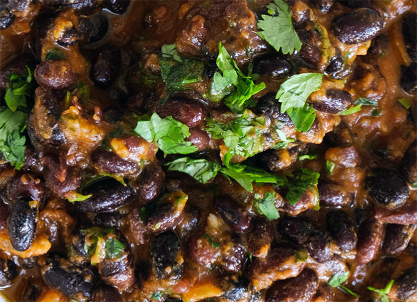 black-eyed bean and diced banana peel stew served topped with chopped coriander leaves