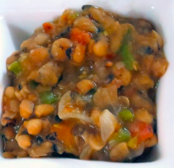 stew of beans, tomatoes, onions and green bell pepper in a white bowl