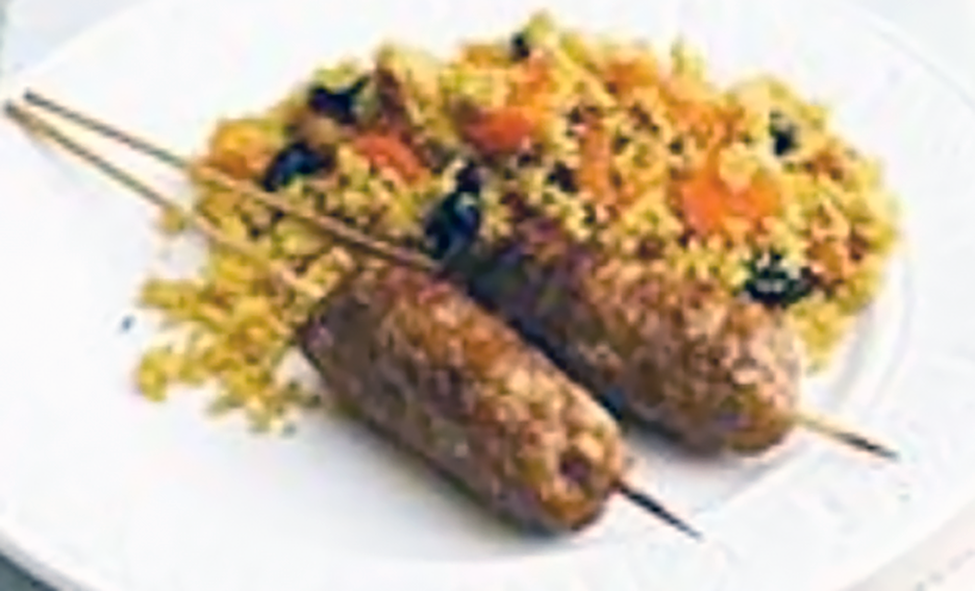 two beef koftas served beside fruity couscous