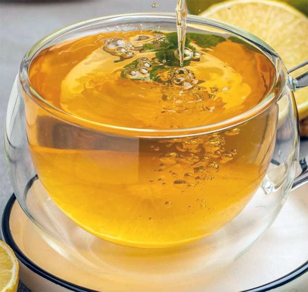 bergamot and orange tea in a glass tea cup garnished with a bergamot leaf