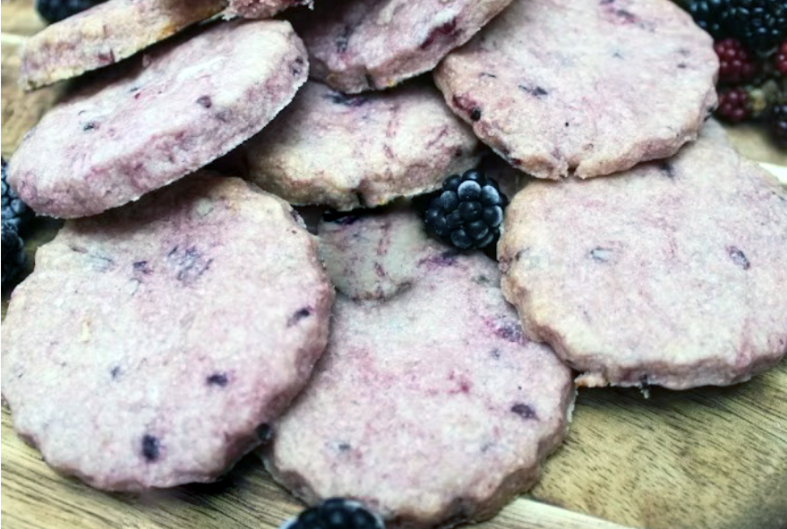 blackberry shortbread biscuits piled on a wooden board