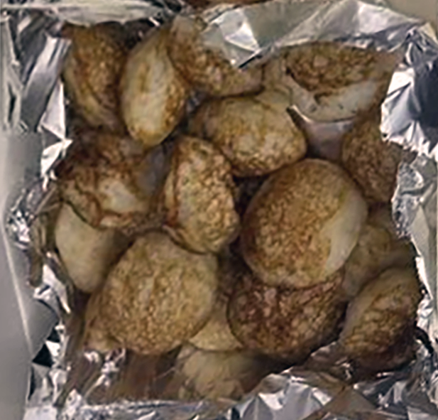 Bourmassa, fried yeasted pastries in a box lined with foil