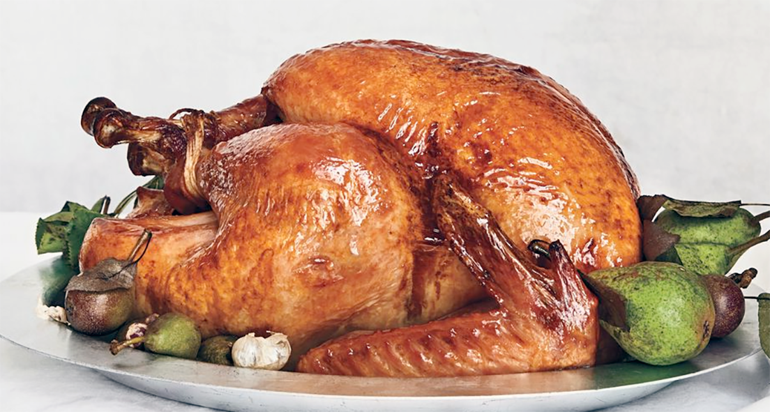 brined and roasted turkey on a silver dish with a garnish of fruit