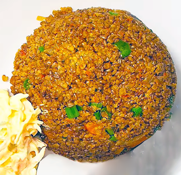 bulgur wan pot served in a mound on a plate and accompanied by coleslaw