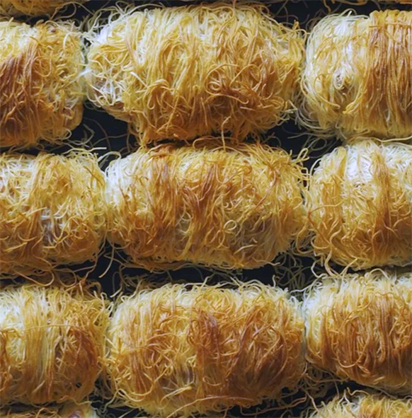 string pastry rolls with walnut filling on a baking tray