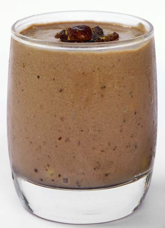 date, nut milk, banana and carob smoothie in a glass