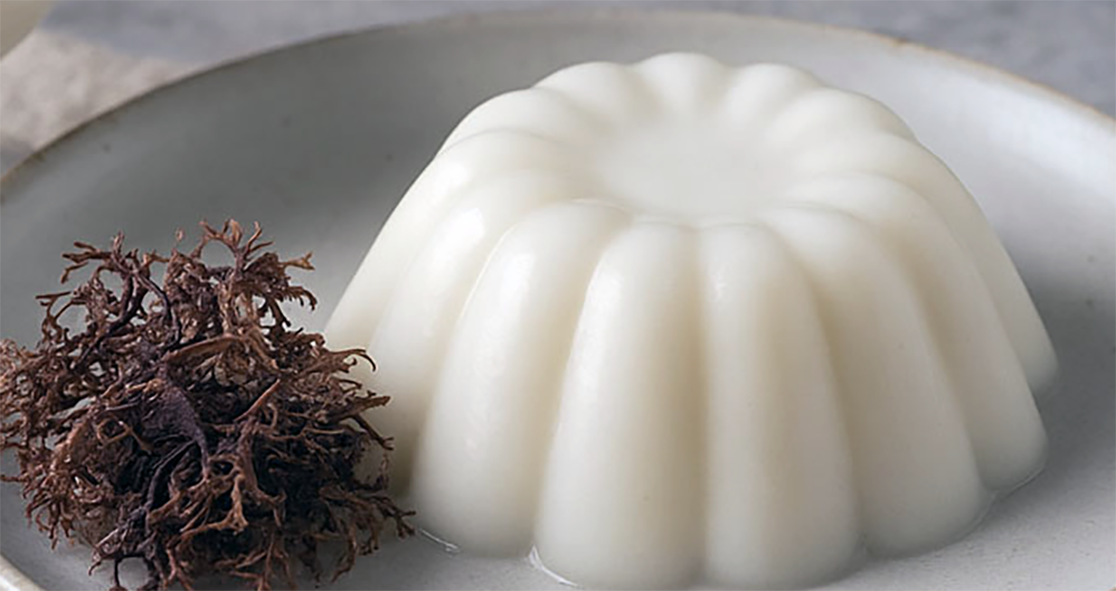 Carrageen pudding turned out onto a bowl next to a pile of dried carragheen seaweed