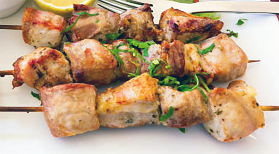 three pork kebabs arranged on a plate