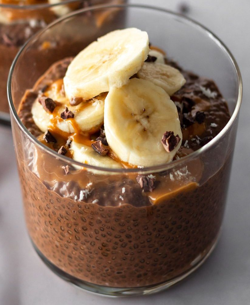 chocolate chia seed pudding topped with bananas in a glass