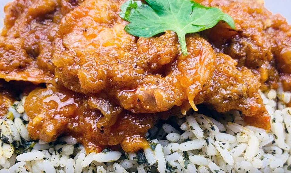 meat and fish cooked with palaver sauce served on a bed of herbed rice