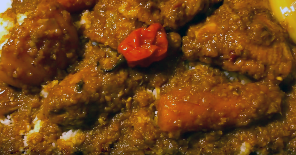 fried chicken with cabbage and carrots in a tomato sauce served on a bed of couscous with a whole chilli