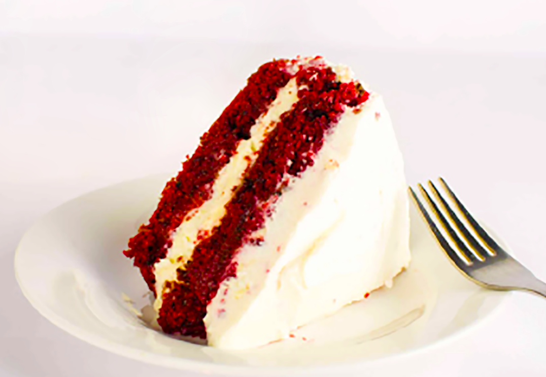 wedge of red velvet cake on a plate with a fork