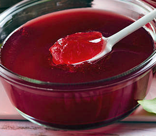 cornelian cherry jelly in a glass bowl with a spoon