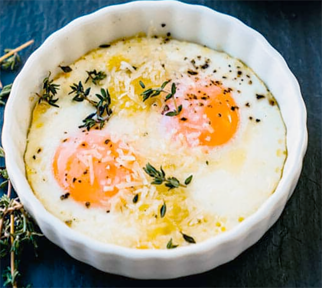 two baked eggs on a bed of chorizo sausage and chillies served topped with thyme