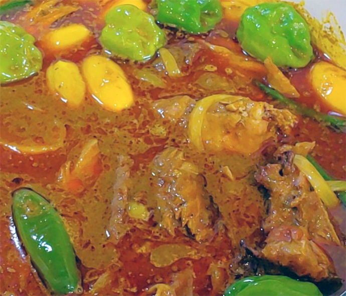 whole chillies and smoked fish in a palm soup base