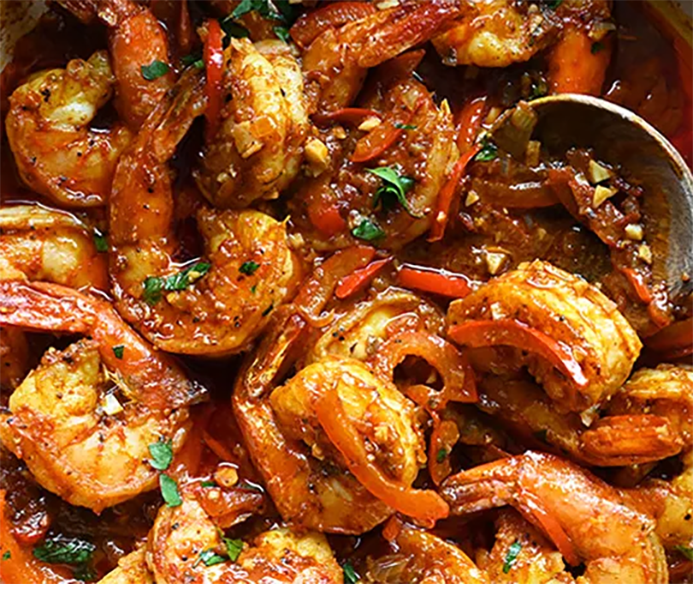 Djerba-style barbecued harissa prawns in a bowl with a spoon