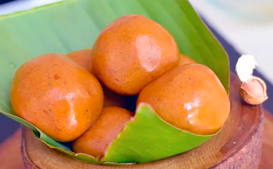 spiced peanut paste balls served in a banana leaf