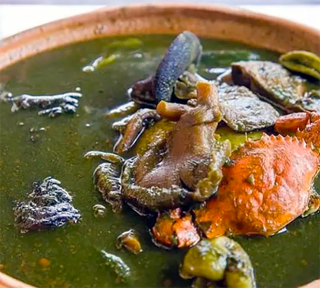 mixed meats in a spicy soup base coloured green with taro leaves