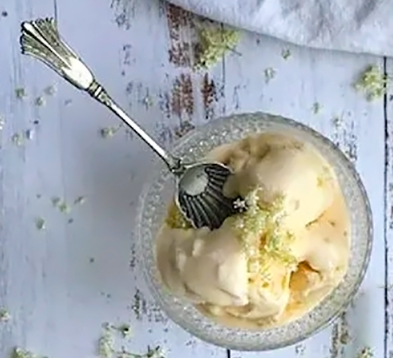 elderflower ice cream in a glass bowl with a spoon