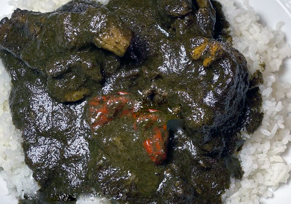 stew of beef and garden eggs in a jute mallow leaf base served on a bed of rice