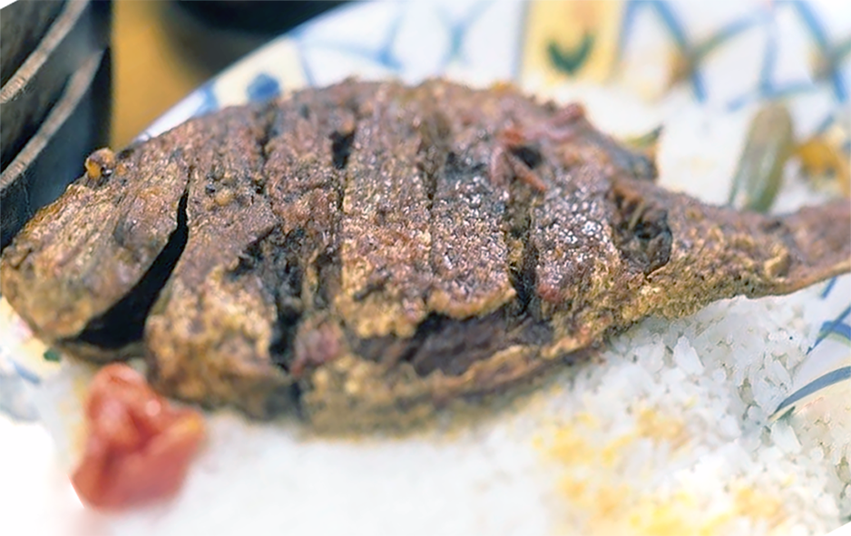 crisp-fried whole fish served on a bed of rice with a whole chilli garnish