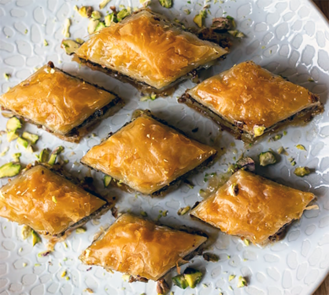 diamonds of pistachio (fistikli) baklava arranged on a white plate