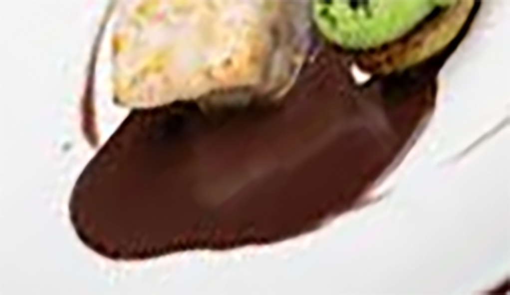 Plate with matelote sauce poured below avocado toast and halibut steak