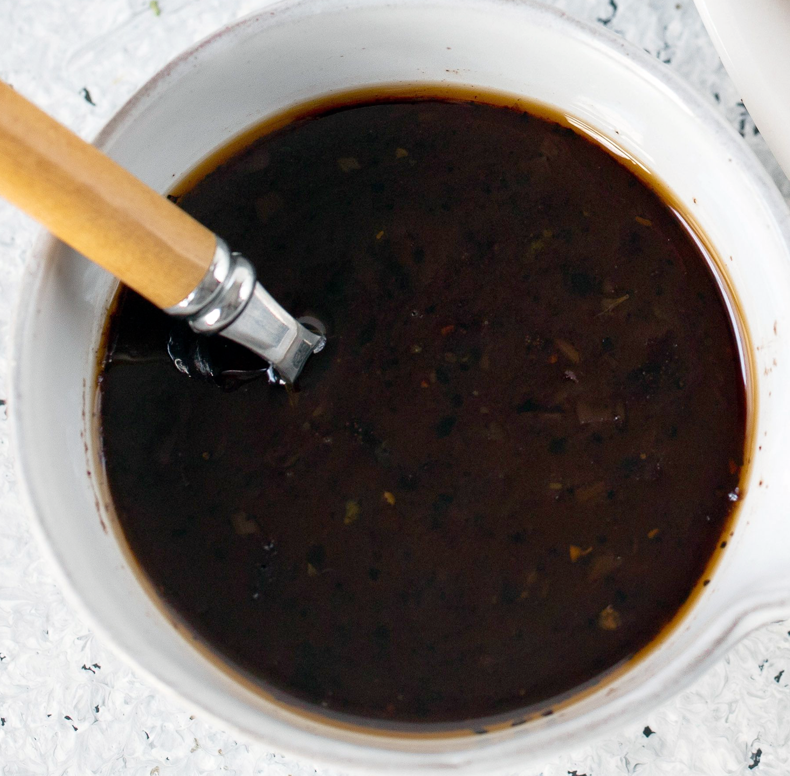 Chateaubriand sauce in a white bowl with a spoon