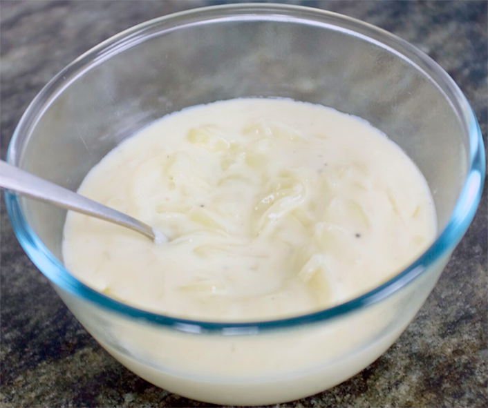 White onion sauce in a bowl with a spoon