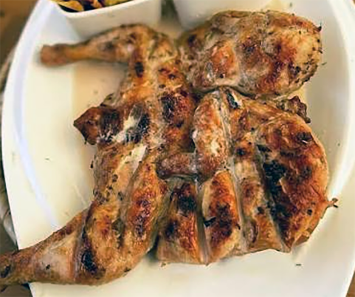 barbecued marinated spatchcocked chicken presented on a plate