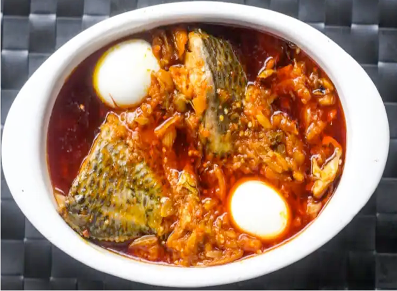 stew of garden eggs served with fish and hard-boiled eggs in an oval dish