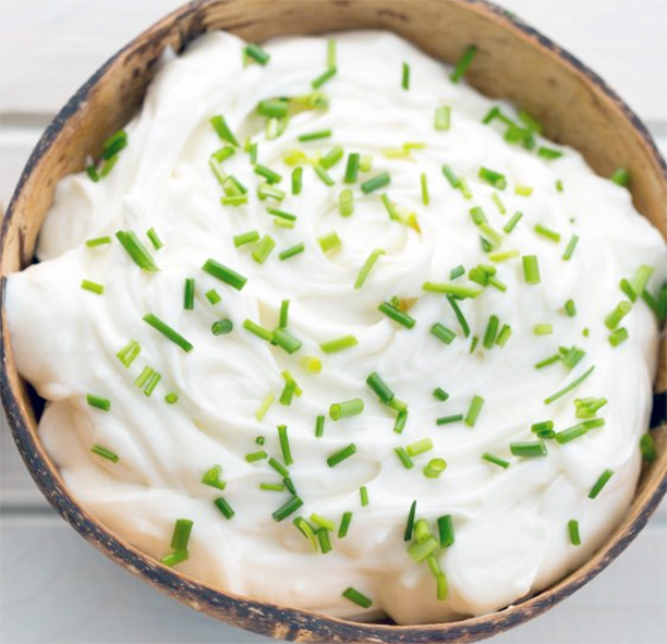 Garlic and chives sauce with chive garnish presented in a wooden bowl