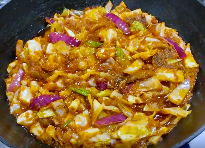 ghanaian stew of cabbage and onion with meat in a tomato base with chillies