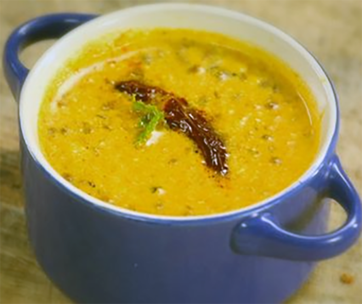sunflower seed and chironji nut paste in a spiced base with yoghurt served in a bowl garnished with a chilli