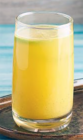 Ivorian ginger juice in a tall glass with a slice of lime