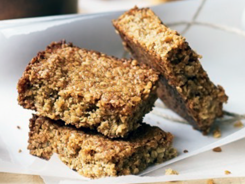 Three squares of golden syrup flapjacks arranged on greaseproof paper