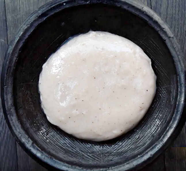 green bananas cooked to a smooth paste and served in a black earthenware bowl