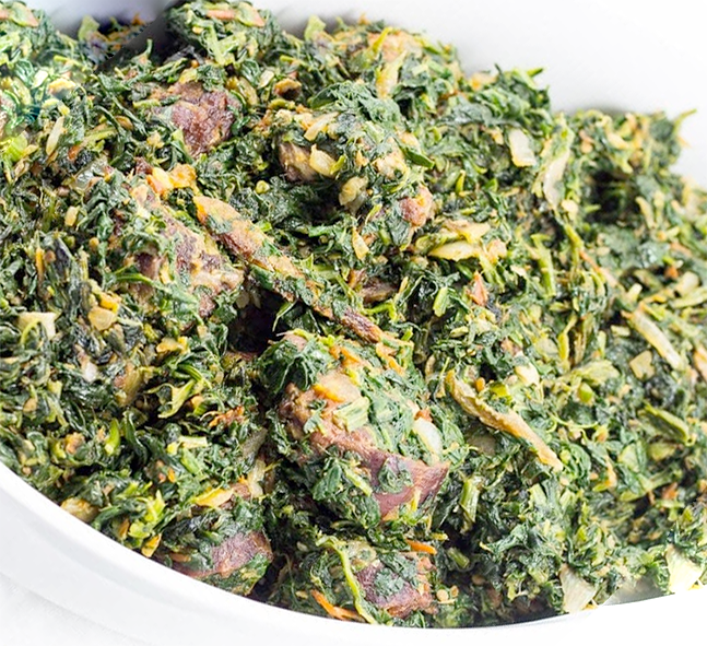 green stew presented in a white serving dish