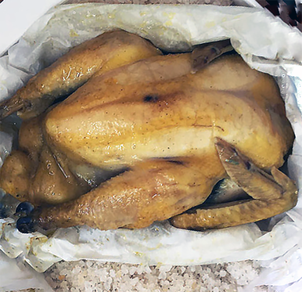salt-baked Sichuan chicken being unwrapped in its baking dish