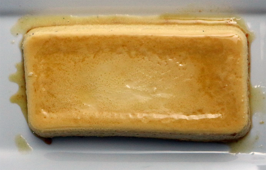 honey syrup topped condensed milk and egg flan on a white plate