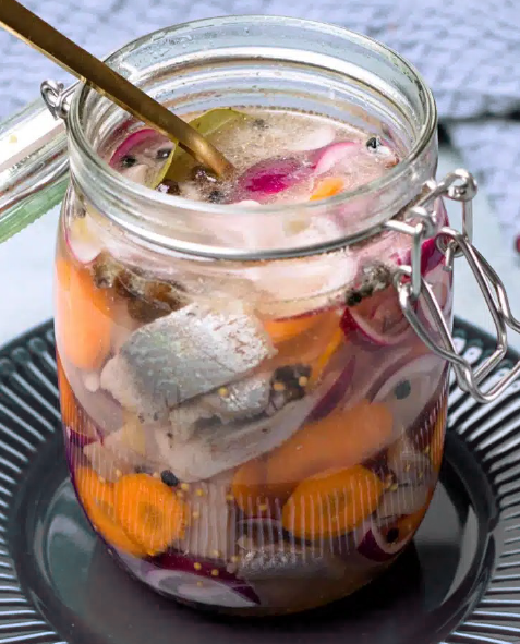 Swedish pickled herring in a jar with carrots and onions