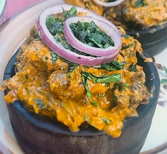 isi ewu, spicy goat head served in a wooden bowl