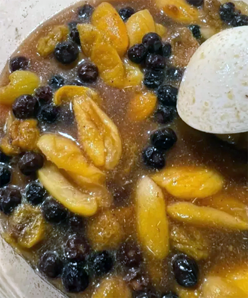Iranian fruit khamas served in a bowl with a spoon of powdered sugar