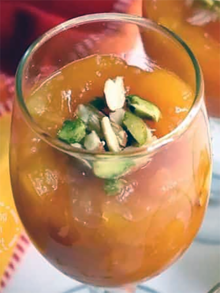 Khubani ka Meetha, Indian apricot mousse in a wine glass with a garnish of pistachio nuts