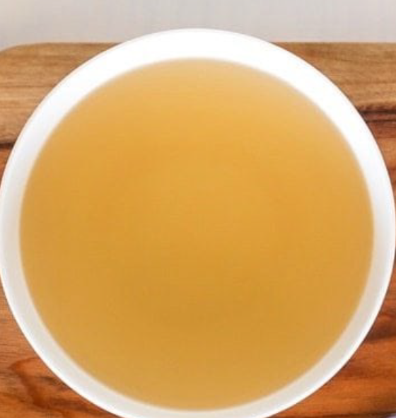 Korean-style Dashi sauce in a white bowl on a chopping board
