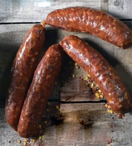 four cypriot loucanika sausages on a wooden table