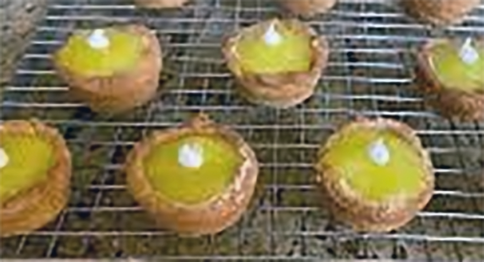 lemon curd tassies garnished with a dollop of cream cooling on a wire rack