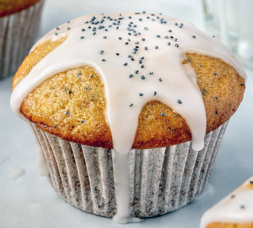 lemon poppy seed cupcake in a paper case with a lemon and poppy seed glaze