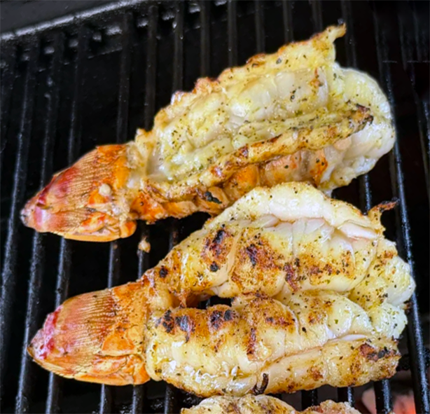 lobster tails cooked on a barbecue with a lemon juice baste