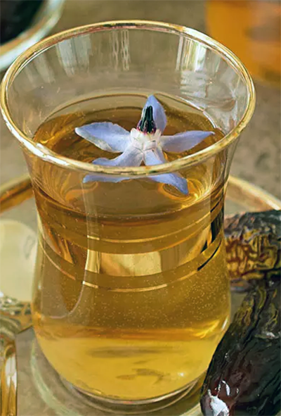 loomi, dried lime tea served in a glass garnished with a borage flower